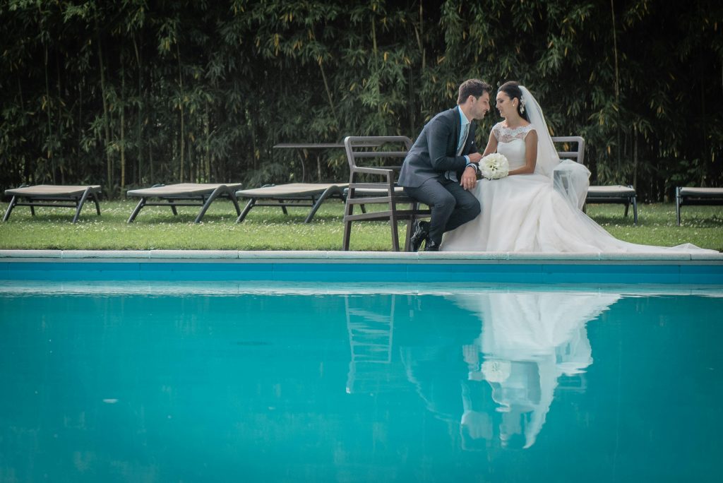 Elegant wedding couple sharing a moment by the pool in Como, Italy.
